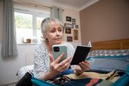 Senior woman holding a passport and smartphone
