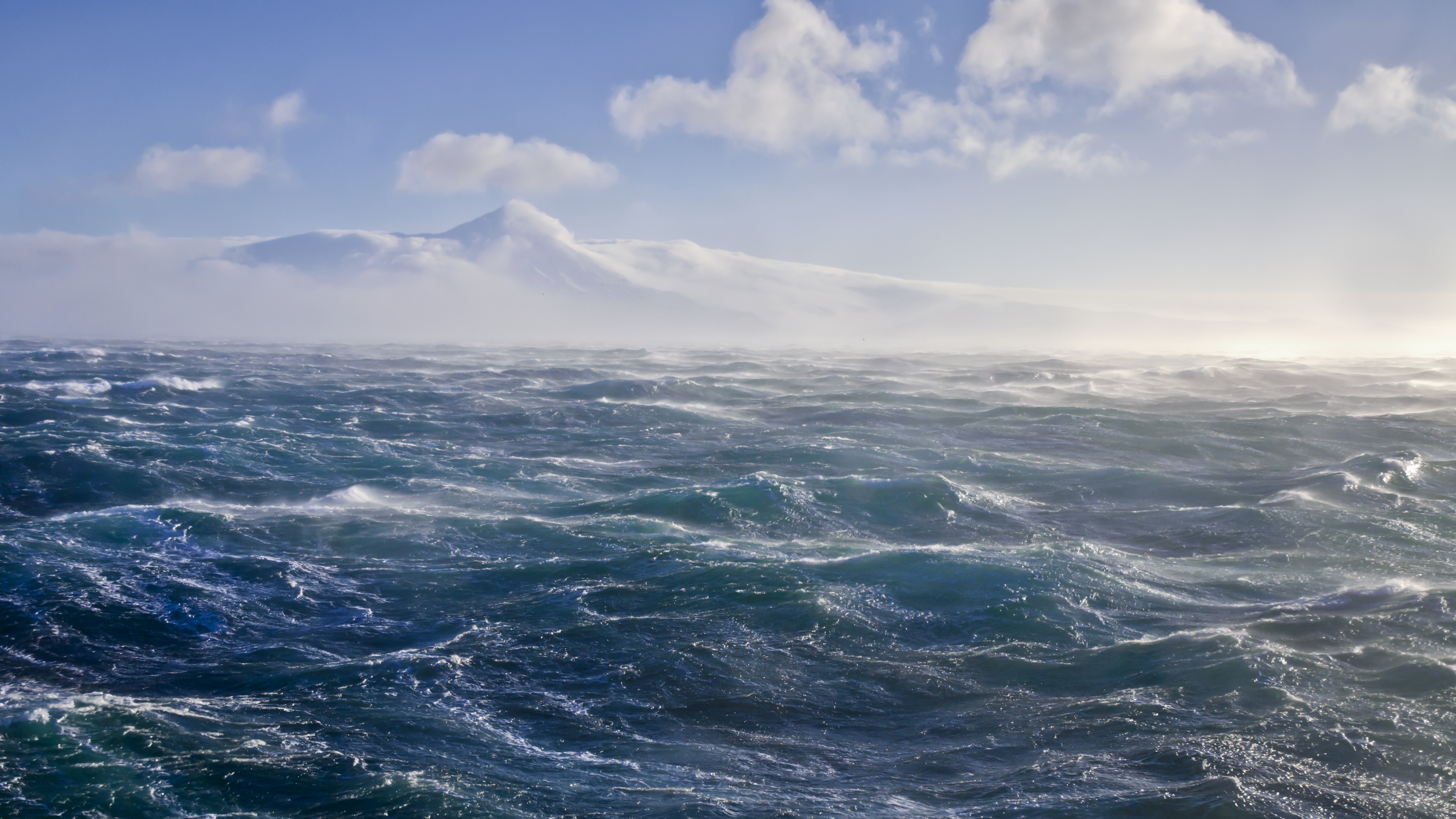 a storm sea with ice mountains in the background