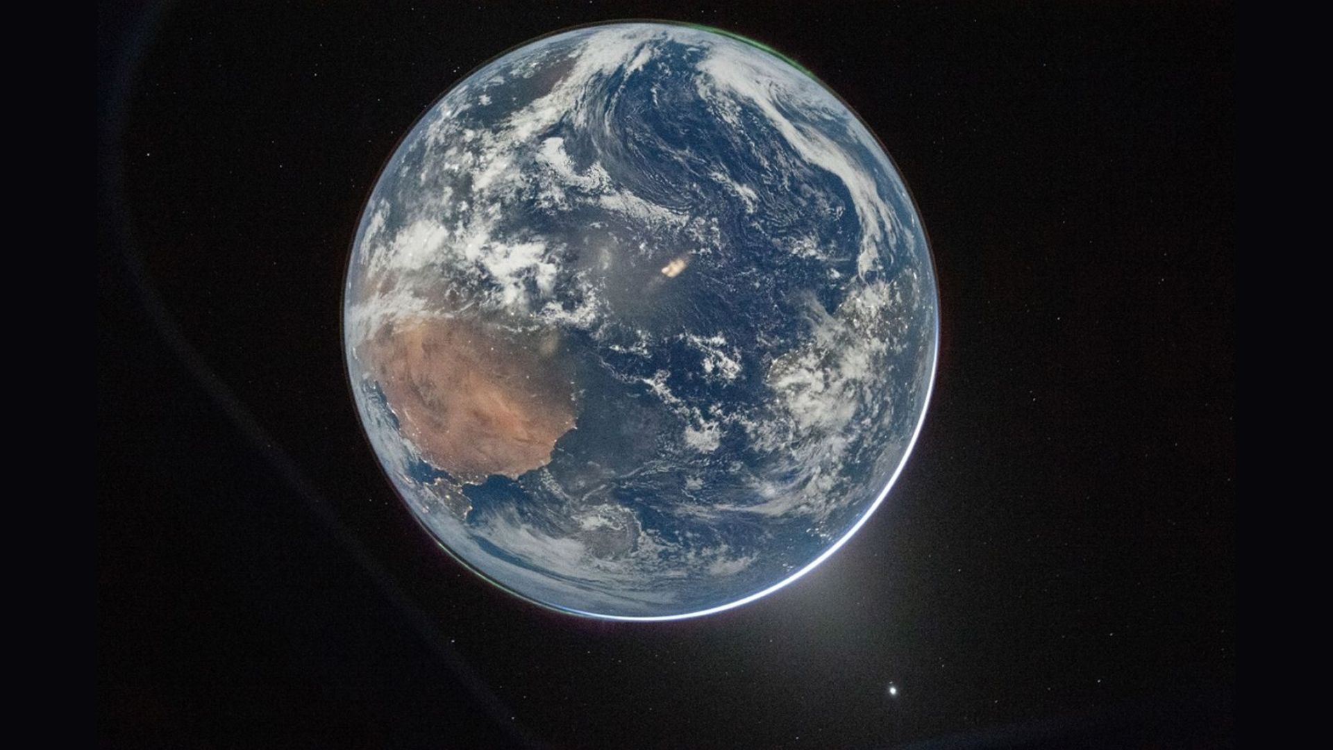 A view of Earth with a glow behind it.