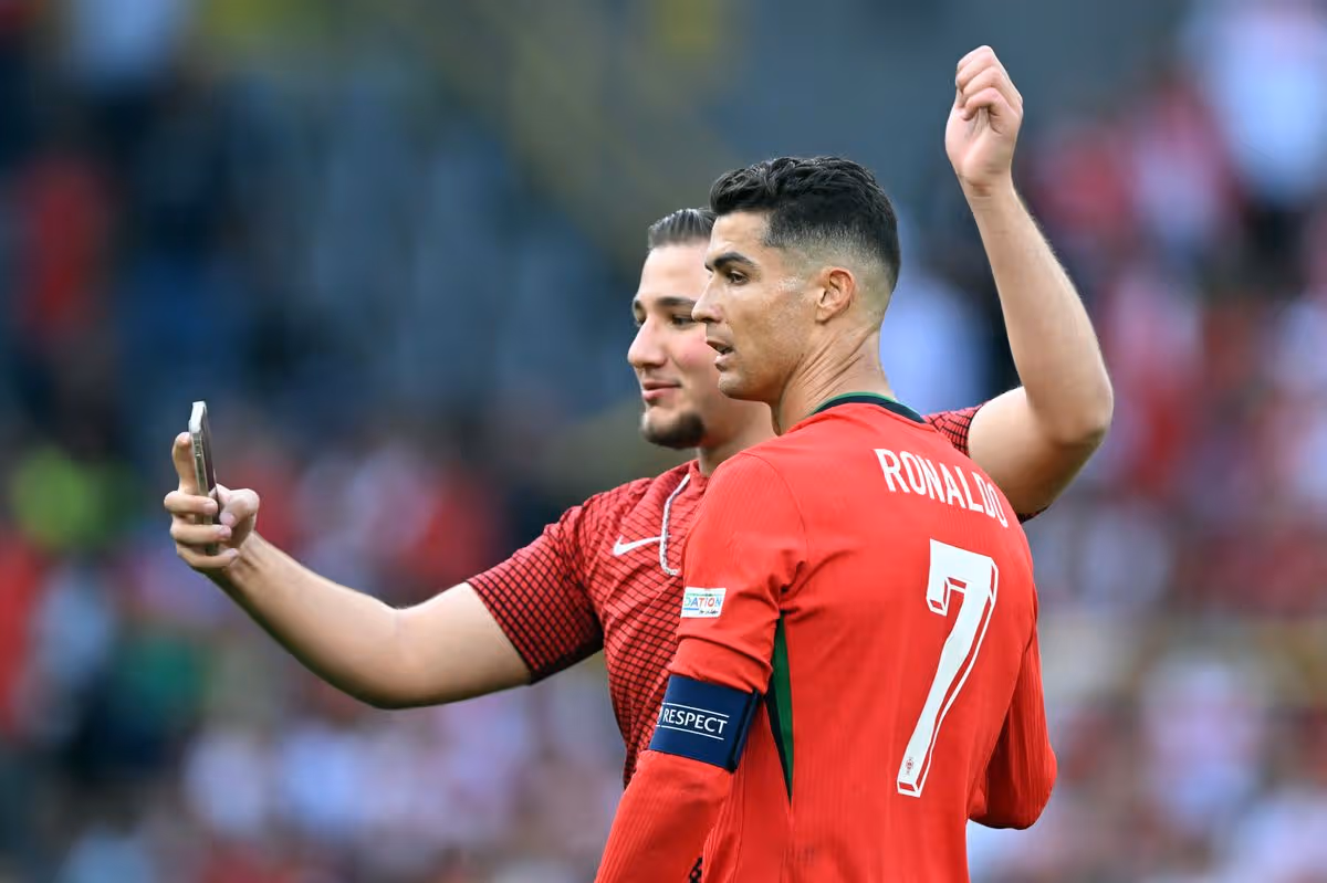 A fan attempts to take a selfie with Ronaldo