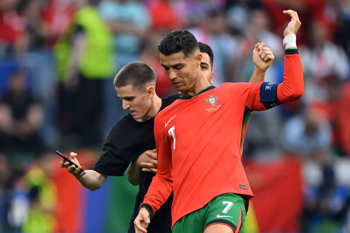 A fan storms the pitch and grabs Cristiano Ronaldo
