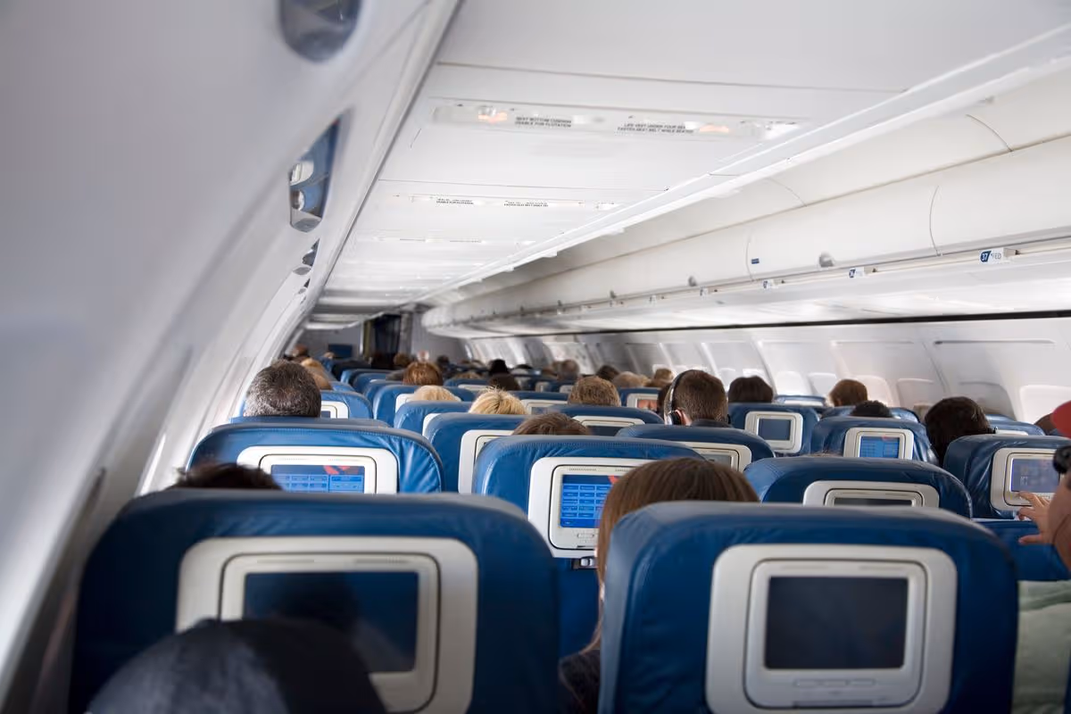 "All seats full on this flight, showing back of heads."