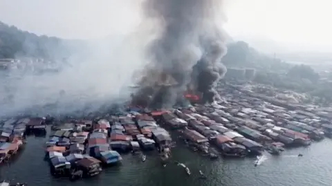 Houses on fire with thick smoke travelling upwards
