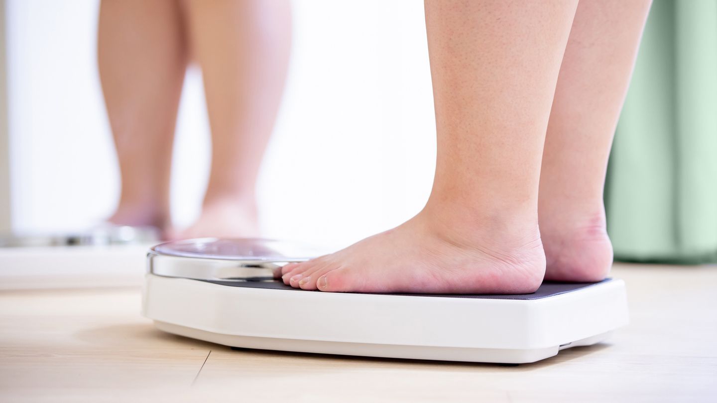 overweight feet on a bathroom scale