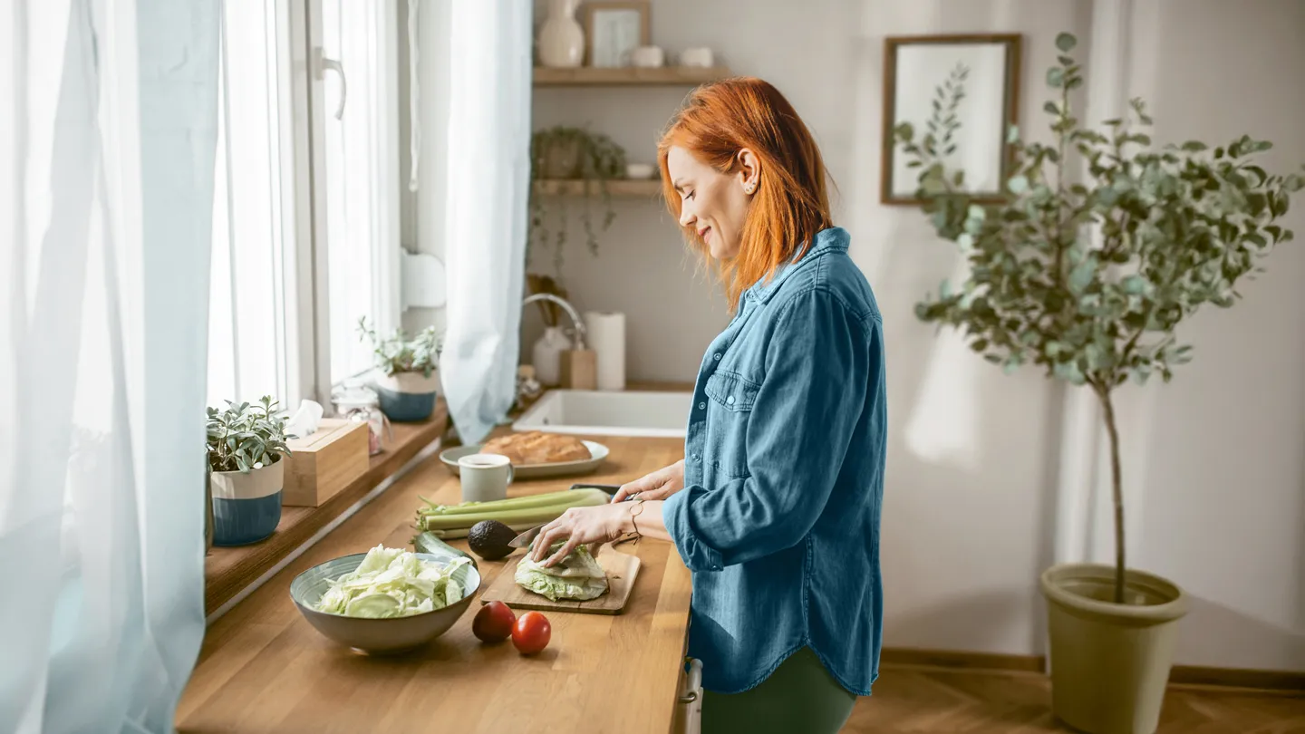 Woman cutting vegetables in kitchen