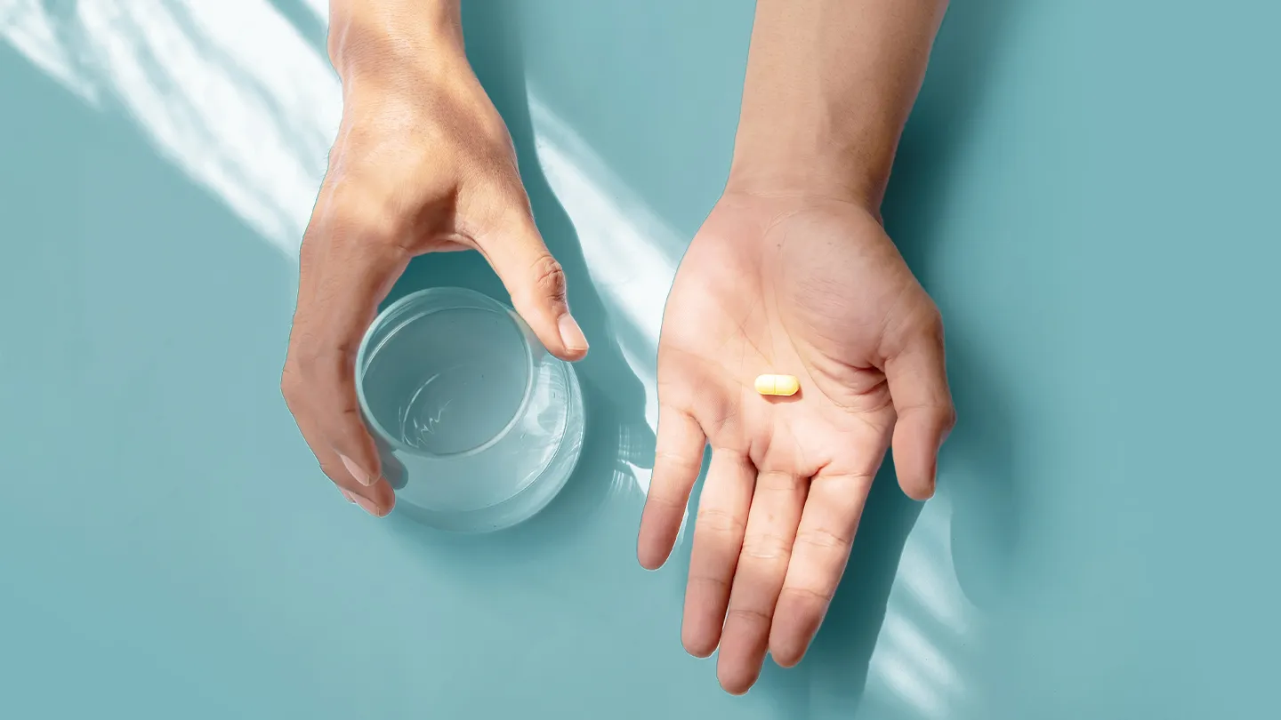 hands holding n-acetylcysteine and water