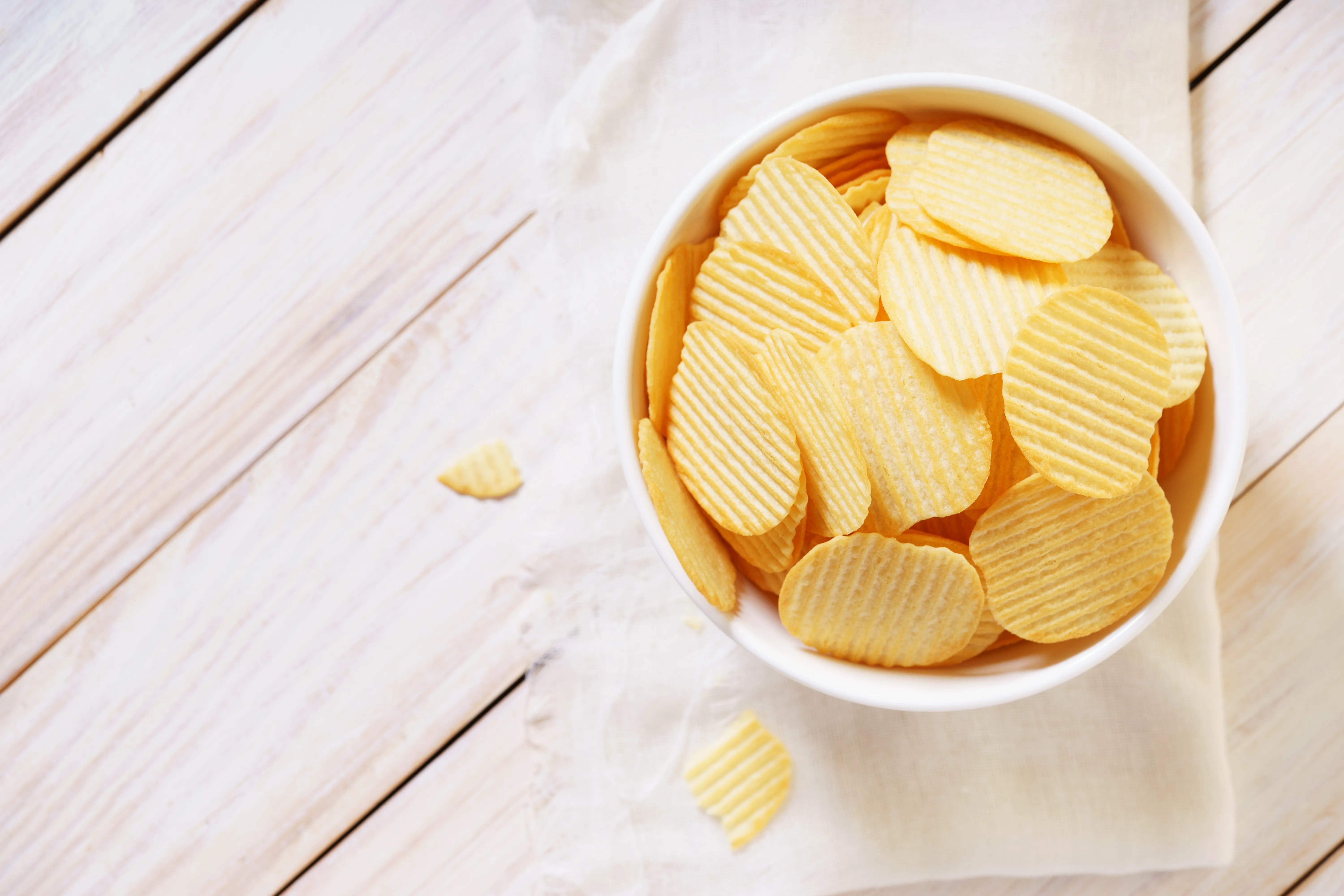 crispy potato chips in a white bowl