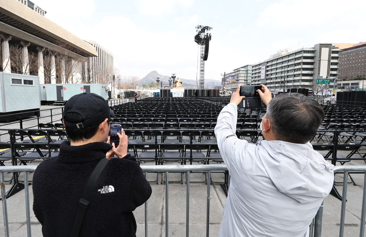 A day before BTS’s comeback performance, citizens take photos at the concert venue in Gwanghwamun Square, Seoul, on Friday. (Yonhap)